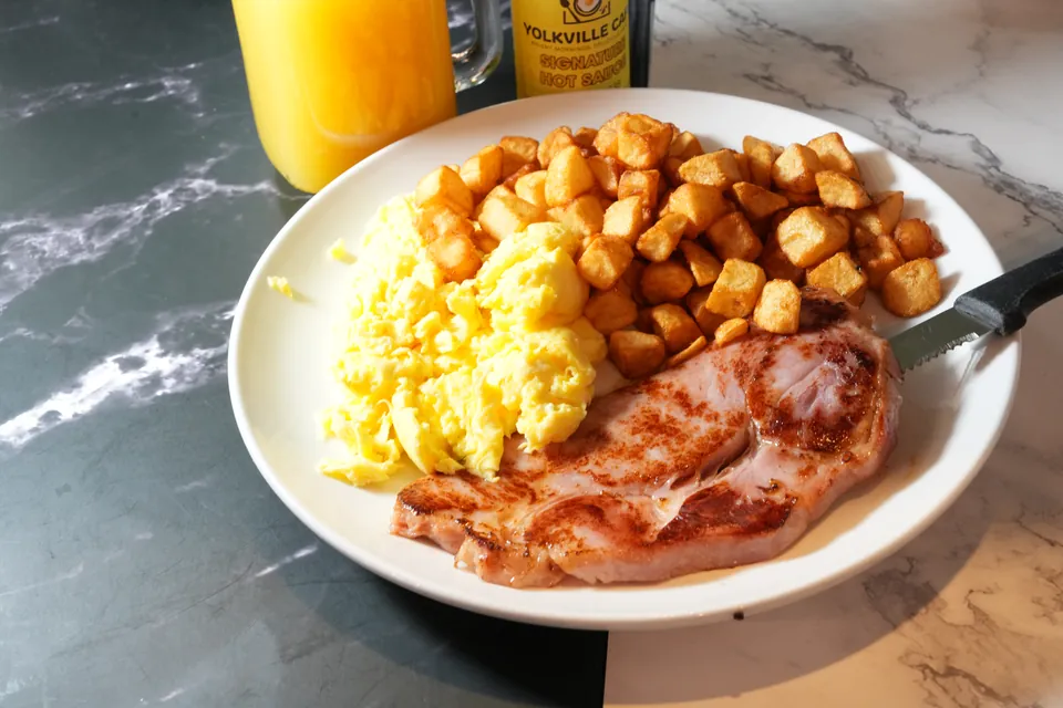 Ham steak and eggs with a bottle of Yolkville Signature Hot Sauce