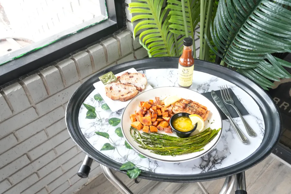 Grilled salmon plate on a marble bistro table by the cafe window