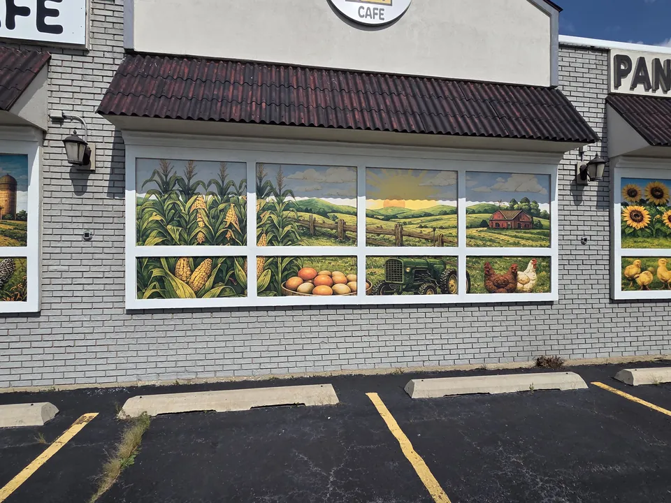 Window murals of corn fields, a tractor and a basket of eggs